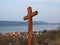 Wooden cross at pilgrimage route by lakeside village