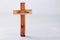 Wooden cross with text He is risen on grey background. Reminder of Jesus sacrifice and Christ resurrection. Easter passover.