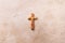 Wooden cross with text He is risen on marble background. Reminder of Jesus sacrifice and Christ resurrection. Easter