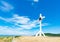 A wooden cross on top of a hill. Orthodox white cross glows on the top of the hill on the background of blue sky and of green gras