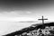 A wooden cross on top of Subasio mountain, with a sea of fog below and Assisi town (Umbria) in the background