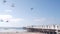 Wooden Crystal pier on piles with white cottages, California ocean beach, USA.