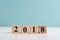 Wooden cube with 2018 label for new year decoration on pastel ba