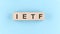Wooden cube block with text IETF Internet Engineering Task Force on the blue background