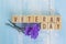 Wooden cube block veteran day word with purple flower