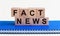 Wooden cube with flip block FACT News word on table background. News, solution and business concepts