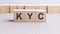 wooden cube with the letter KYC. KYC - short for Know Your Customer