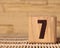 Wooden cube with the number seven on a beige background