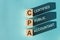 Wooden cubes building word CPA - abbreviation of certified public accountant - with shadows on light blue background