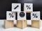 Wooden cubes in a column and a row with white signs with a smiley sign, an arrow, a percentage. The concept of