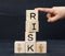 Wooden cubes with the inscription risk on a blue background. Risk reduction concept, reinsurance