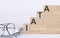 Wooden cubes with letters IATA on the white table with keyboard and glasses