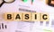 Wooden cubes with letters on the table in the office. Text BASIC