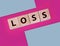 Wooden cubes with LOSS word on pink magenta. Financial loss business concept