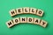 Wooden cubes with message Hello Monday on green background, flat lay