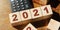 Wooden cubes with numbers 2021 and calculator. The beginning of the new year. Financial year concept
