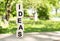 Wooden cubes are stacked vertically on a wooden table in the garden. The word IDEAS is written in black letters.