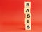 Wooden cubes with word BASIS. Wooden cubes on a red background. Free space on the left