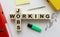 Wooden cubes with words JOBS WORKING on the office desk. Folder and other office supplies