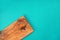 Wooden cutting board from olive tree on turquoise background. Cooking, recipe concept.