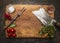 Wooden cutting board with Slasher meat fork meat pepper salt tomatoes, fresh herb top view rustic wooden background