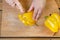On a wooden cutting board woman stealing a yellow pepper knife on a round slice. Close-up