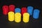 Wooden cylinders painted red blue and yellow on dark background