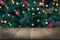 Wooden dark tabletop and blurred christmas tree bokeh. Xmas background for display your products.