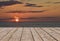 Wooden deck floor over colorful sunrise sunset background