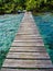 Wooden deck over tropical waters, connecting the bungalow to the beach