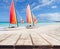 Wooden deck perspective with two colorful catamarans