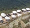 wooden deck for relaxing and sunbathing with sun loungers and white umbrellas on the shore of the clear transparent sea