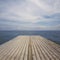 Wooden deck terrace over sea and sky. Summer background