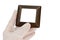 Wooden design plastic light switch frame, wood imitation surface held in fingers of left hand in transparent latex glove