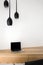Wooden desk and black hanging lamps
