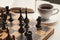 Wooden desk with chess play, book and coffee cup