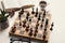 Wooden desk with chess play, book and coffee cup