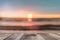 Wooden desk of free space with sea background at sunset