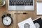 Wooden desk with a laptop, cactus, black clock, notebook in circles