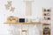 Wooden desk with a laptop, sewing machine, organizer and macrame o a wall next to a shelf. Empty screen, place you