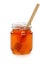 Wooden dipper with jar of honey.