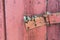 Wooden dirty red blank aged door for backdrop with rusty latch - closeup