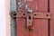 Wooden dirty red blank aged door for backdrop with rusty latch - closeup