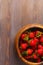 wooden dish with strawberries. wood background, top view