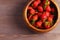 Wooden dish with strawberries. wood background, view from above, space for a text