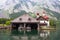 Wooden dock for boats with a temple and mountains in the background on Konigssee Lake, Austria