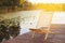 Wooden dock with lounge chair on pier on the calm lake in the middle of the forest