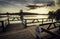 Wooden dock with a [Perigo - danger] sign on a river under a dark cloudy sky in the evening