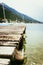 Wooden dock pier extending over blue lake water and mountains, blurry background