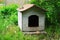 Wooden doghouse in the grass near the house